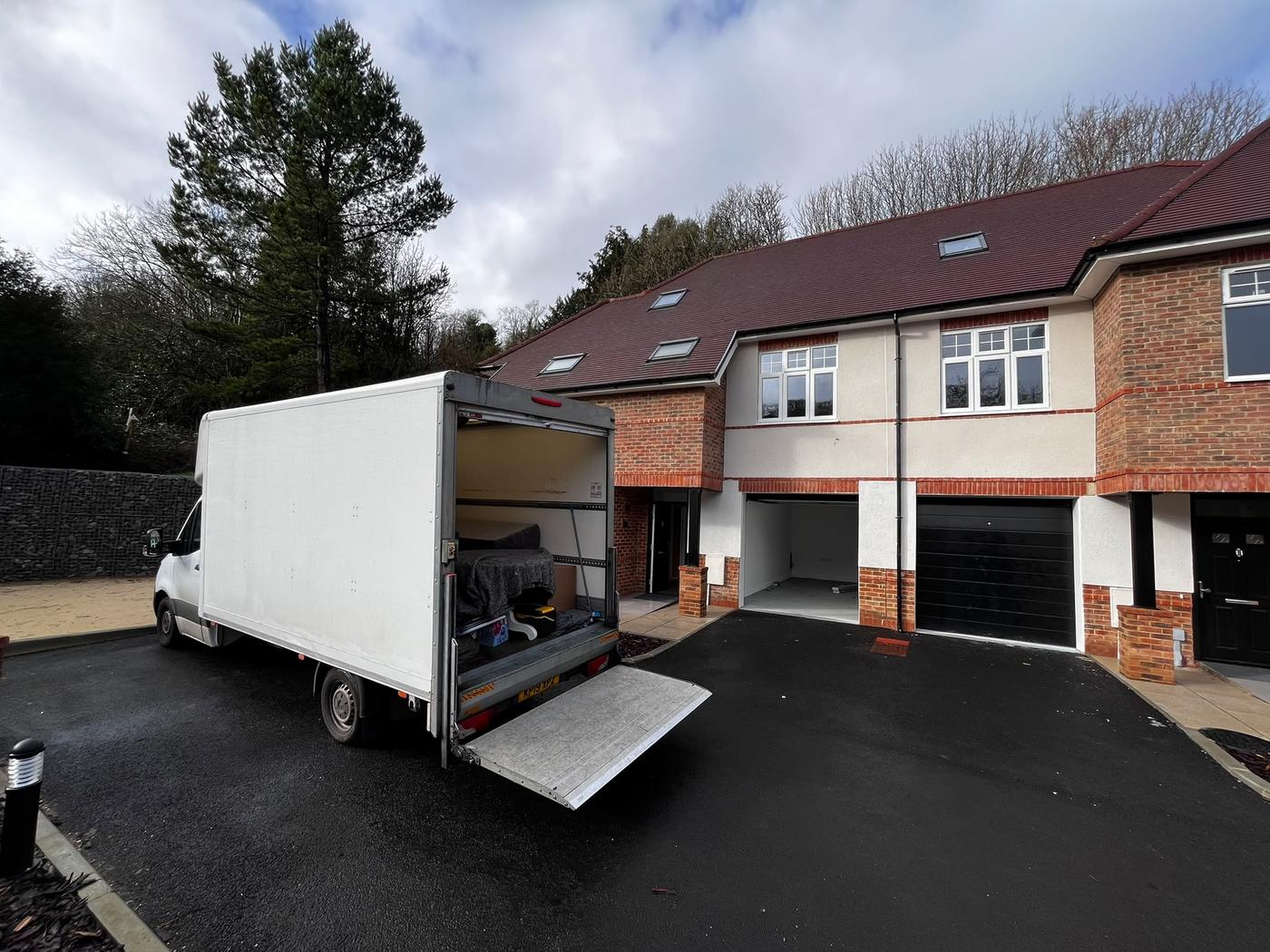 A Fastiya Logistics Luton van with its tail lift down on a new-build driveway